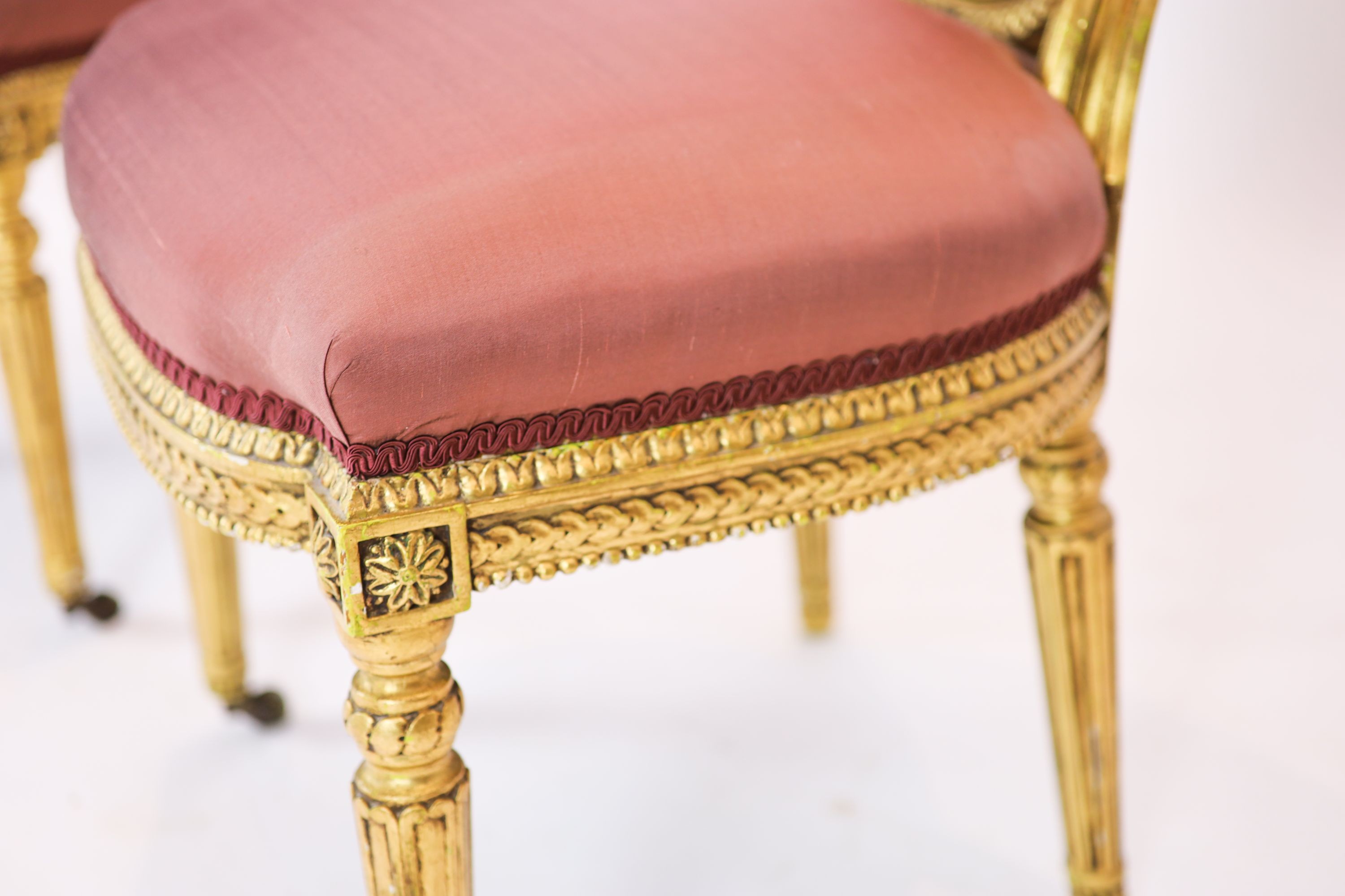 A pair of 19th century Louis XV style giltwood framed side chairs, with oval carved backs, on turned and fluted legs